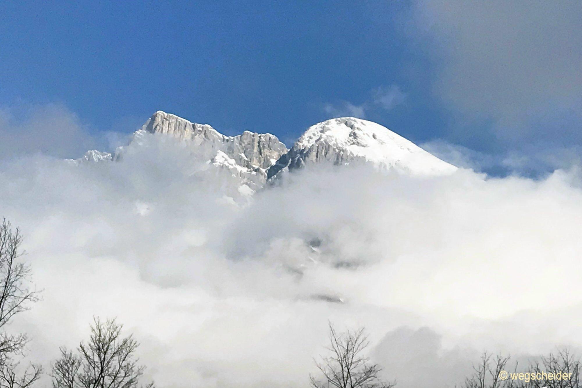 Verschneite Berge ragen aus dem Nebel
