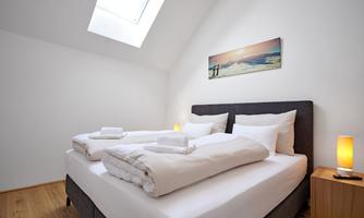 <p>A modern bedroom with a double bed and fresh bedding. A skylight provides natural light and a relaxed atmosphere.</p>