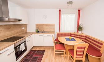A modern kitchen with bright cabinets and a dining set. The room is designed to be friendly and inviting.