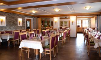 An inviting restaurant with several covered tables and warm wooden furniture. The atmosphere is cozy and friendly.