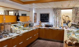 An inviting buffet with a variety of foods and drinks. The warm wood look and decorative elements create a cozy atmosphere.