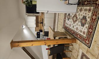 A cozy kitchen with a dining table and chairs. The room has a modern look with wooden details and tiled floor.