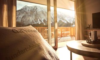 <p>A cozy apartment with a view of the Grimming. Warm light streams in through large windows.</p>