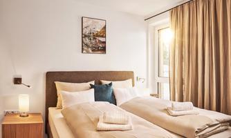 <p>A cozy bedroom with a double bed and a bright window front. Soft colors and modern furnishings create a relaxed atmosphere.</p>