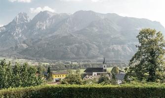 A relaxing view of the mountains with a picturesque landscape. Two lounge chairs are on a green meadow.