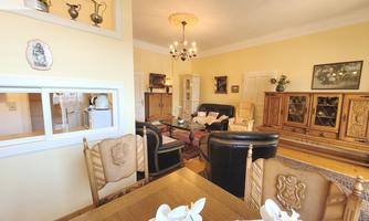A cozy living room with traditional furniture and beautiful decoration. The walls are painted in a soft shade of yellow, creating a warm atmosphere.