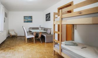 A bright room with a bunk bed and a modern dining table. The furniture is simple and functional, ideal for a cozy accommodation.