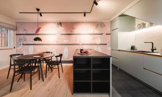 A modern kitchen with an elegant dining table and chairs. The walls are decorated with a delicate floral pattern.
