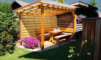 A cozy wooden terrace with a table and benches.  
Surrounded by colorful flowers and a green meadow.