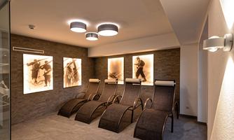 A modern relaxation room with comfortable loungers and stylish wall art. The pleasant lighting creates a calm atmosphere.