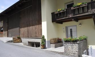 A cozy building with a wooden facade and a modern entrance. Colorful flower boxes create an inviting atmosphere.