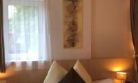 A cozy bedroom with a large bed and comfortable pillows. The room has large windows that provide plenty of daylight.