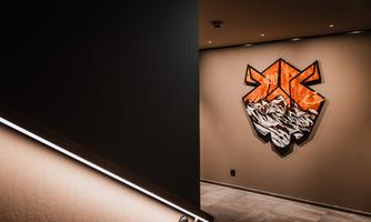 A modern hallway with a minimalist staircase and soft lighting. A striking graffiti in orange and white hangs on the wall.