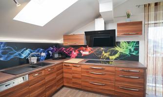A modern kitchen with wooden cabinets and a colorful wall design. It is bright and has a skylight that lets in daylight.