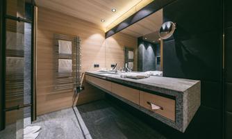 A modern bathroom with wood paneling and an elegant sink. The lighting creates a pleasant atmosphere.