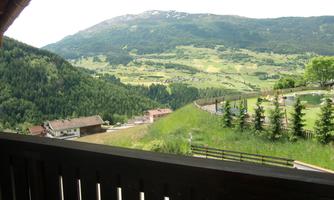 An impressive view of green landscapes and mountains. The scene features a calm, natural environment with houses and trees.