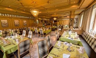 A cozy restaurant with wooden furniture and elegant lighting. The tables are lovingly set and invite you to linger.