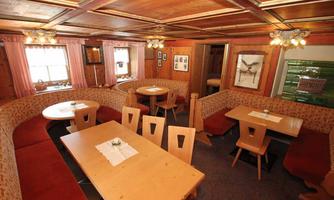 A cozy room with wooden furniture and comfortable seating. Soft lighting and a rustic ambiance create an inviting atmosphere.