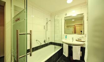 A modern bathroom with a bathtub and shower. Bright tiles and a bright atmosphere create a pleasant ambiance.