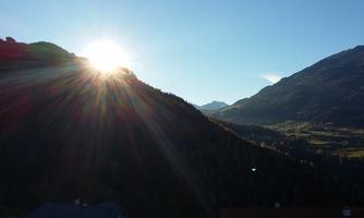A breathtaking mountain landscape in the morning light. The sun rises behind the hills and illuminates the valleys.
