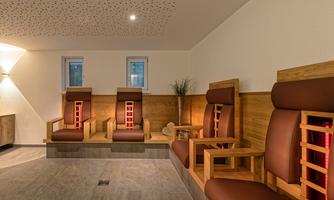 A modern relaxation room with comfortable loungers and gentle wooden elements. The warm light creates a calm atmosphere for relaxing.