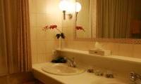 An elegant bathroom with two sinks and a large mirror wall. Fresh flowers give the room an inviting touch.