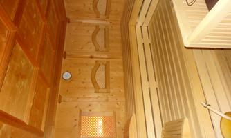 A cozy sauna with wooden-paneled walls and benches. The atmosphere is relaxed, perfect for unwinding and rejuvenating.