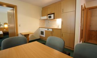 A modern kitchenette with a table and chairs. The room feels cozy and inviting.