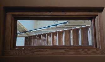 A simple wooden frame shows a staircase leading upwards. The room is bright and feels inviting.