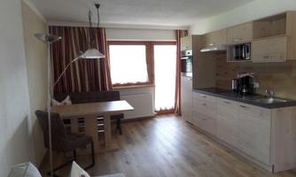 A bright and modern kitchen with a dining area. The room is comfortably furnished and has large windows that bring in plenty of light.
