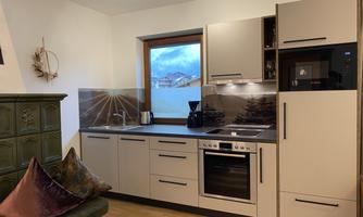 A modern kitchen with bright cabinets and a window that offers a view of the mountains. The space is well-lit and inviting.