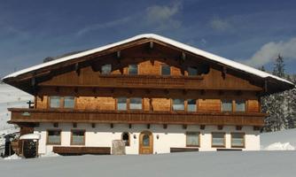 A traditional alpine hut in the snow with wooden cladding. The surroundings are wintry and peaceful.