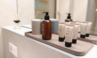 A stylish bathroom with care products on a tray. The bottles and tubes exude naturalness and elegance.
