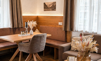 A cozy dining area with wooden paneling and modern furniture. The lighting and decor create an inviting atmosphere.