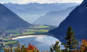 A picturesque landscape with mountains, a lake, and a green meadow. The area is tranquil and idyllic, perfect for nature lovers.
