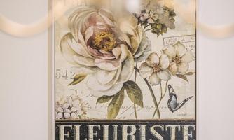 A decorative picture with floral motifs in soft colors. The text "Fleuriste, Rue du Parfumeur" stands prominently in the lower area.
