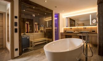 A modern bathroom with a freestanding bathtub and a sauna. Soft light and wood paneling create a relaxing atmosphere.