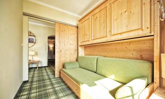 A cozy room with a green sofa and wood paneling. The decor is modern and inviting.