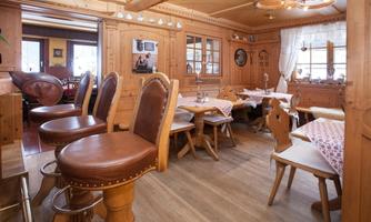 A cozy restaurant with wooden furniture and an inviting atmosphere. The tables are set in a rustic style and invite you to linger.