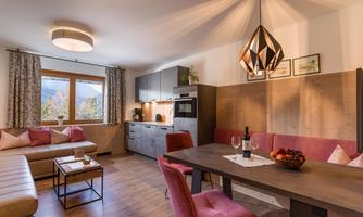 A modern kitchen with a cozy dining area. The room is bright and friendly, with elegant furniture and a warm atmosphere.