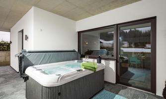 A modern hot tub on a terrace with an elegant setting. The space is bright and inviting, perfect for relaxation.