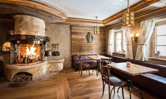 A cozy restaurant with an open fireplace and wooden interior. The atmosphere is warm and welcoming, perfect for relaxed gatherings.