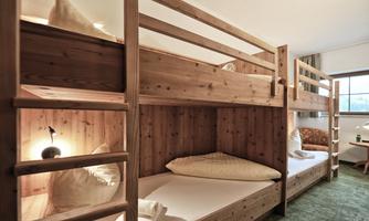 A cozy bedroom with wooden bunk beds. The room is bright and inviting, ideal for groups or families.