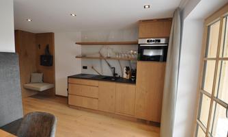 A modern kitchen with wooden shelves and an elegant countertop. The decor is bright and inviting.