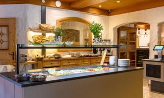An inviting restaurant with a buffet area. There are fresh ingredients and a cozy atmosphere.