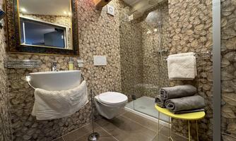 A modern bathroom with an elegant shower cubicle and a stylish sink. The walls are decorated with a unique pattern and fresh towels are ready.