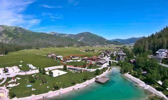 A picturesque landscape with gentle hills and a clear river. Small buildings and an idyllic environment invite relaxation.