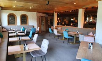 A modern restaurant with comfortable seating in various colors. The atmosphere is bright and inviting.