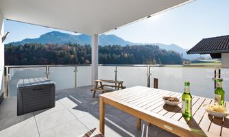 A cozy terrace with a view of the mountains. Drinks and snacks are on the table.
