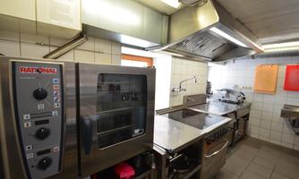A modern kitchen with stainless steel appliances and cooktops. The space is bright and well-organized.